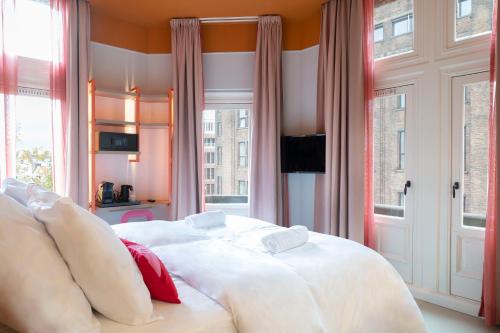 a bedroom with a large white bed with red pillows at City Hotel Rembrandt Square - Just renovated in Amsterdam
