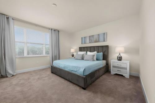 a white bedroom with a bed and a window at Cozy 3bd 3bath @HiddenForest with pool in Orlando