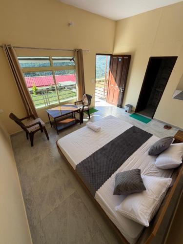ein Schlafzimmer mit einem großen Bett und einem großen Fenster in der Unterkunft Tathastu Resorts in Tehri-Garhwāl