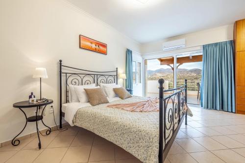 Un dormitorio con una cama y una mesa y un balcón. en Lucy Lux Villa, en Milatos
