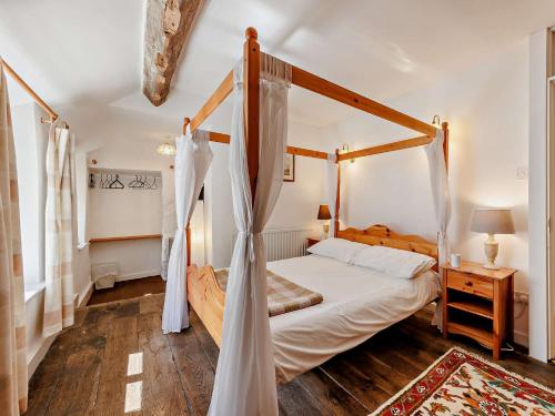 a bedroom with a canopy bed and a wooden floor at 2 Bed in Machynlleth 93082 in Cemmaes