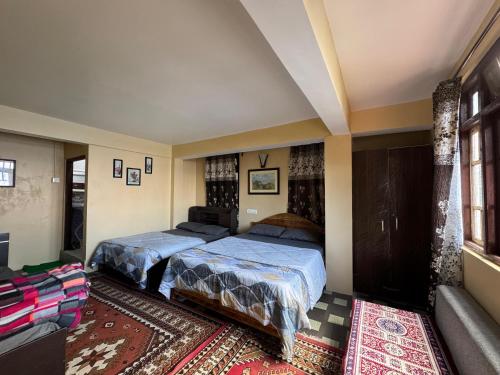un dormitorio con dos camas y un sofá en Nembang Family homestay, en Darjeeling