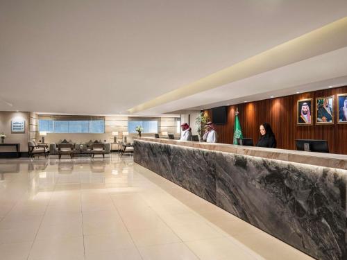 a lobby of a hospital with people sitting at a bar at Anwar Al Madinah Mövenpick in Al Madinah