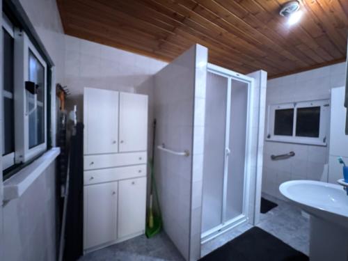 a bathroom with a sink and a white cabinet at Casa da Lúcia in Lajes das Flores