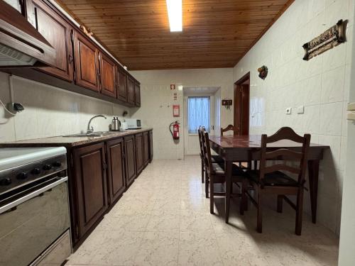 a kitchen with a table and chairs and a sink at Casa da Lúcia in Lajes das Flores