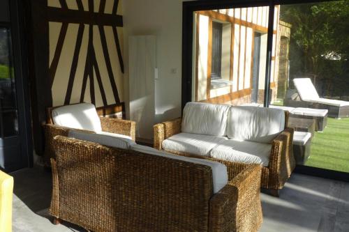 a porch with wicker chairs and a couch at Semi-detached house, Rieux in Rieux