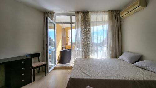 a bedroom with a bed and a large window at Studio F210 - Bulharsko in Aheloy