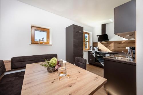 a kitchen and dining room with a wooden table at Panorama Mountain & Castle View Apartment D'Fidlerin Salzburg in Werfen