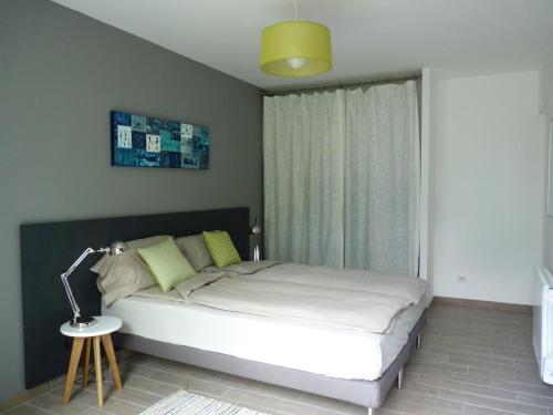 1 dormitorio con 1 cama con lámpara y ventana en A l'Heure d'Eté, en Fargues-de-Langon