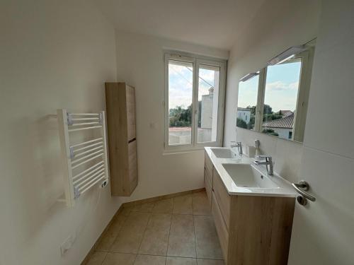 a bathroom with a sink and a window at Colocation Étudiante bompas in Bompas