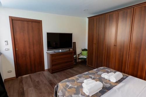 レッジョ・ディ・カラブリアにあるLuna di Sale - Romantic Sea Rooms & Apartmentsのベッドルーム1室(ベッド1台、テレビ、木製キャビネット付)