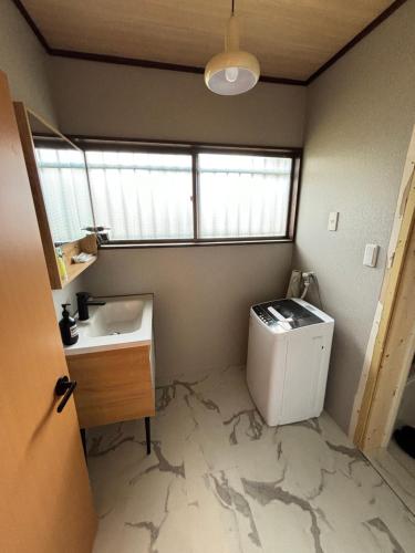a bathroom with a sink and a washing machine at 雲の家 旧東海道沿いの畑宿の温もりステイ in Hakone