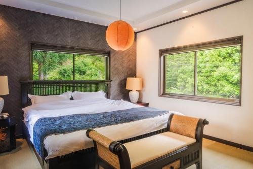 a bedroom with a bed and two windows at 嵐月-嵐山景區內獨棟別墅 in Kyoto
