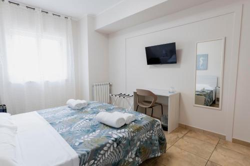 a bedroom with a bed and a desk and a television at Luna di Sale - Romantic Sea Rooms & Apartments in Reggio di Calabria