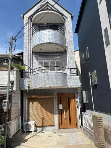 a building with a large door and a balcony at 如家の宿 in Osaka