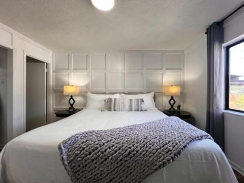 a bedroom with a large white bed with two lamps at Turkey Nest By Beyond Expectations Renovated 2br in Gatlinburg