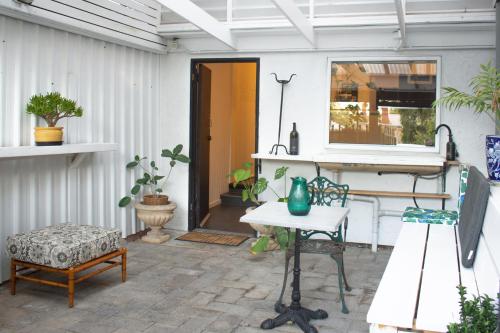 patio ze stołem i krzesłami w obiekcie Adelaide CBD Cozy Stay at Secluded Botanic Cottage with Free Parking w mieście Adelaide