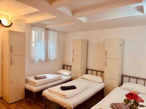 a room with three beds and a window at Opera Central Stay in Budapest