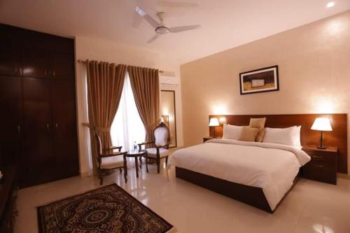 a bedroom with a large bed and a window at Clifton Business Hotel in Karachi