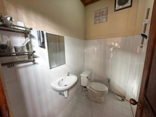 a white bathroom with a toilet and a sink at Mango Villa Nong Khiaw in Nongkhiaw