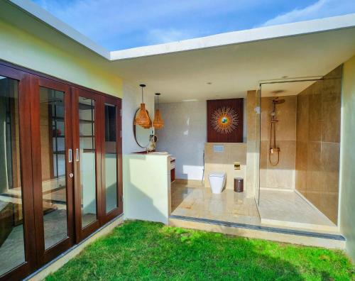 a bathroom with a shower and a toilet in it at KANDORA Luxury villas in Maujawa