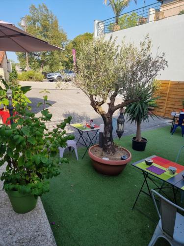 a garden with two tables and a tree on the grass at Amadour Hôtel in Rocamadour