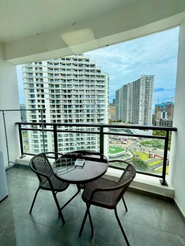 西哈努克SB Condo Sihanoukville -700m to U MALL的阳台配有桌椅和大窗户。