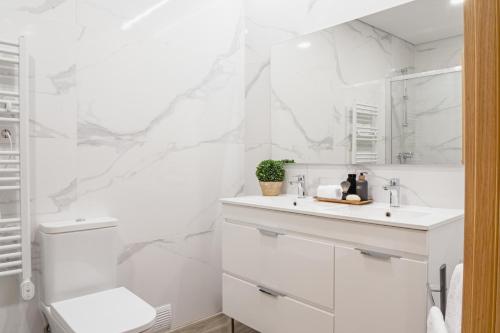 een witte badkamer met een wastafel en een spiegel bij LR Vintage 64 in Vila Real