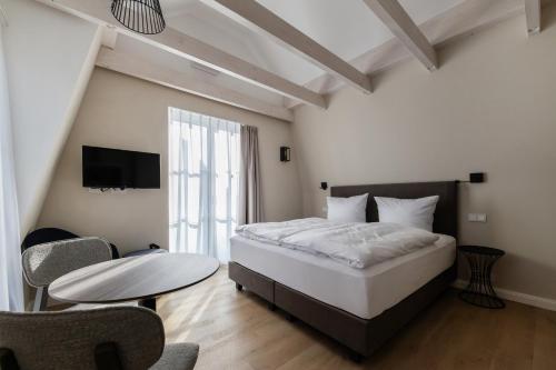 a bedroom with a bed and a table and a tv at Apartotel Berry Hohwacht in Hohwacht