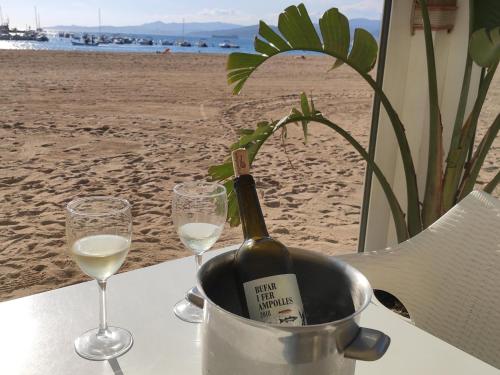 a bottle of wine sitting on a table with two glasses at Villa Paradise in Calonge