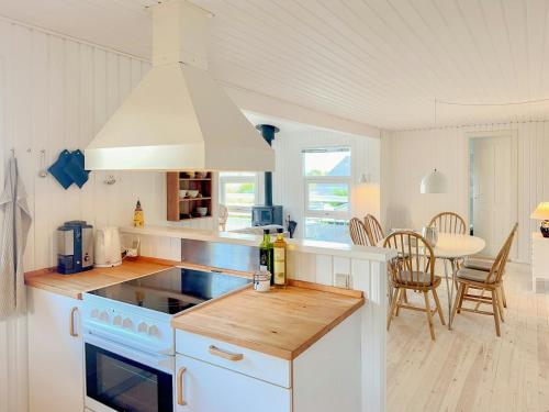 a kitchen with white cabinets and a stove top oven at Sommerhus Med Havudsigt Ved Faldsled in Faldsled