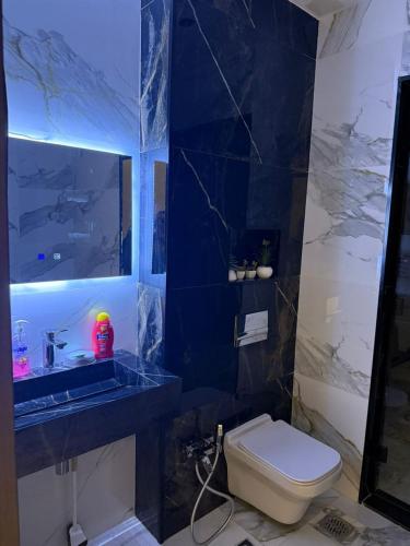 a bathroom with a white toilet and a blue wall at Résidence montana in Deli Ibrahim