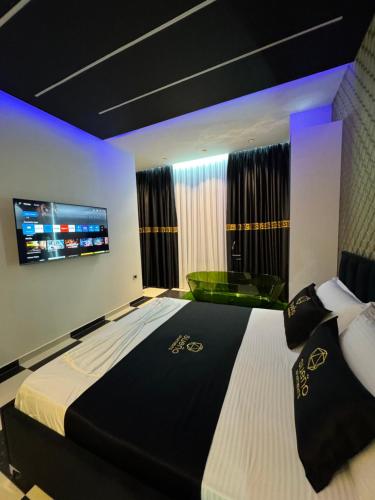 a bedroom with a large bed and a flat screen tv at Modern Sueno Lux Apartments in Tirana