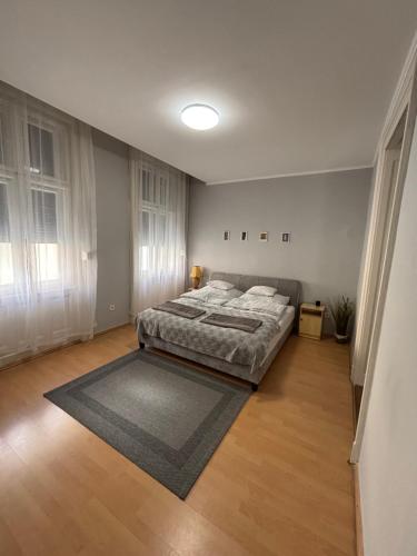 a bedroom with a bed and a rug on the floor at 100 Éves Ház in Esztergom