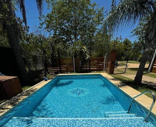 a swimming pool with blue water in a yard at Casa con Pileta a Cuadras de la Playa in Paso de la Patria