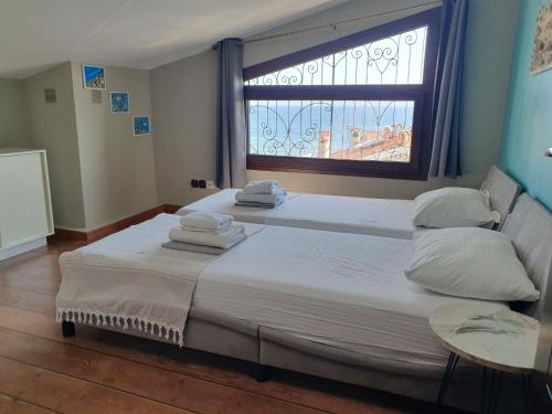 Dos camas en una habitación con una gran ventana. en Teo`s Seaview Apartment Nikiti, en Nikiti