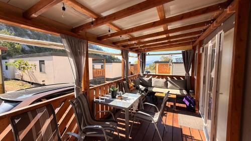 a screened in porch with a table and chairs at Mobile home MARIS in Sveti Juraj