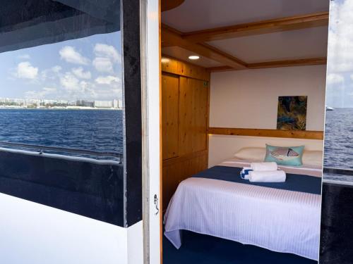 Bett auf einem Boot mit Blick auf das Wasser in der Unterkunft Ritrella Floating Hotel in Male City