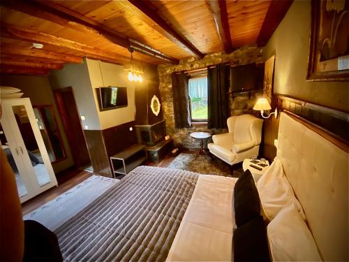 a bedroom with a bed and a chair in a room at Chalet Asteras tou Vorra in Palaios Agios Athanasios