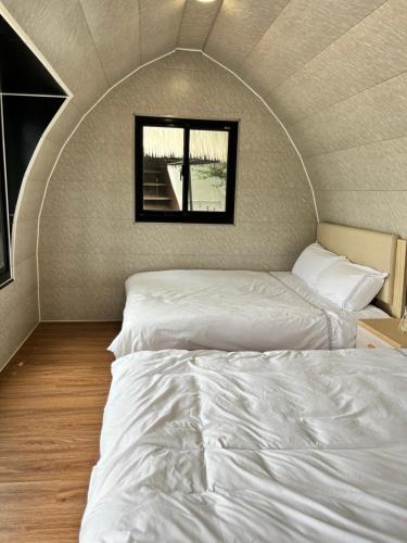 two beds in a room with a window at Yanyu Xihu Villa in Xihu