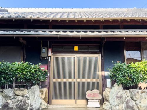 a front door of a house with a gate at ギャラリー宿　INNAHOUSE ANDAGALLERY in Murotsu