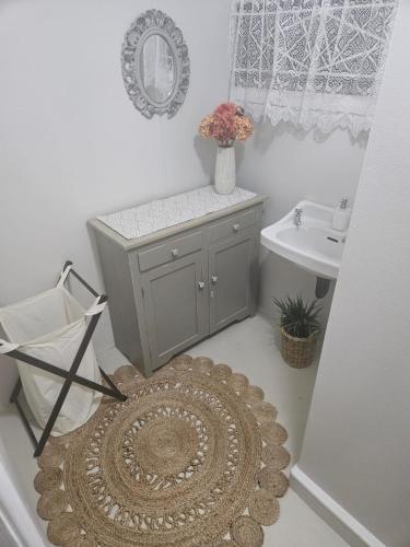 a bathroom with a sink and a rug at Langpouse in Hartenbos