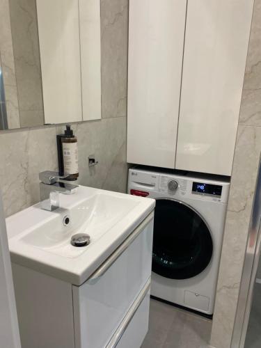 a white sink and a washing machine in a kitchen at Chillout Luxury Touch Apartment - Free Parking Wola Tower in Warsaw