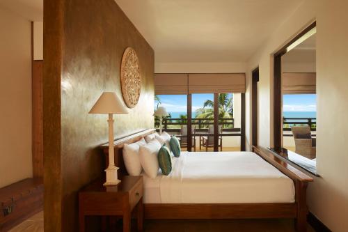 a bedroom with a bed with a view of the ocean at Jetwing Beach in Negombo