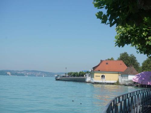 a large body of water with a house and a dock at Pension Ins Fischernetz - Mäntele in Meersburg