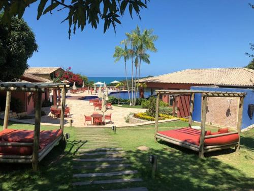 un complexe avec deux lits pivotants et une piscine dans l'établissement Chalé das flores, à Maceió