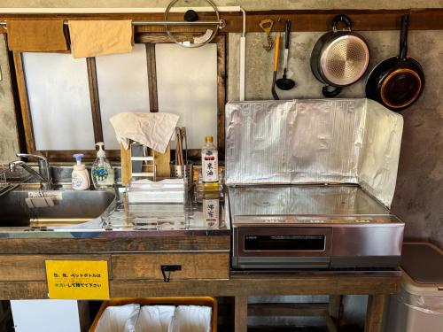 a kitchen with a counter top with a sink and a counter sidx sidx at ギャラリー宿　INNAHOUSE ANDAGALLERY in Murotsu