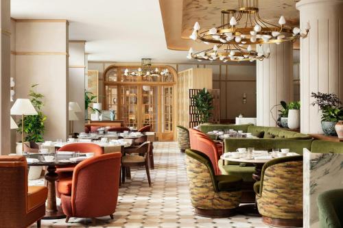 a restaurant with tables and chairs and a chandelier at Montcalm Mayfair, Autograph Collection in London