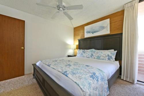 Un dormitorio con una cama grande con ventilador de techo. en Maalaea Banyans 203 · MBN 203 OceanFront 1BD Amazing Ocean Views, en Wailuku