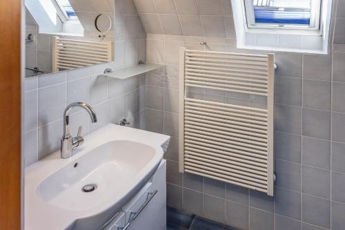 un bagno con un lavandino bianco e uno specchio di Ferienwohnung KUMM RIN - Oase an der Nordsee a Carolinensiel